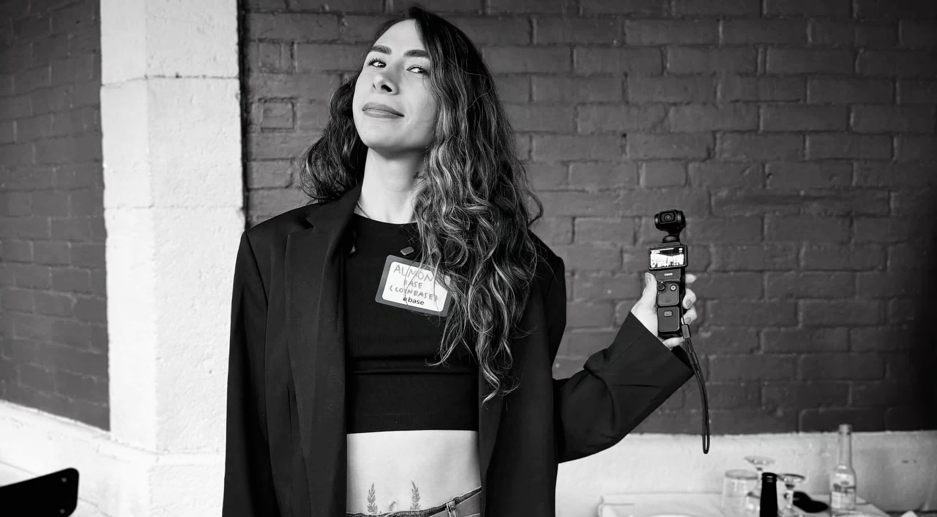 Almond at an event holding a pocket camera