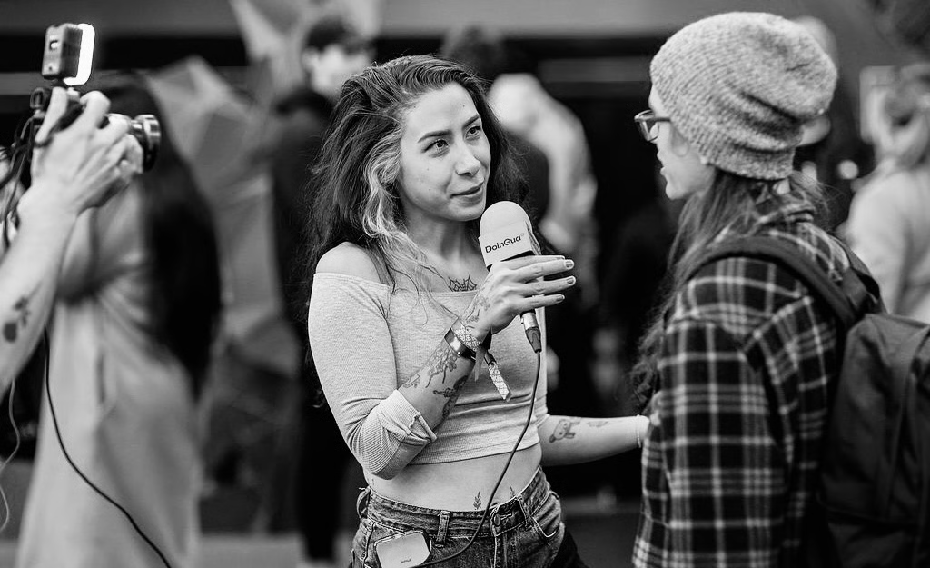 Almond interviewing at a crypto event with a DoinGud mic